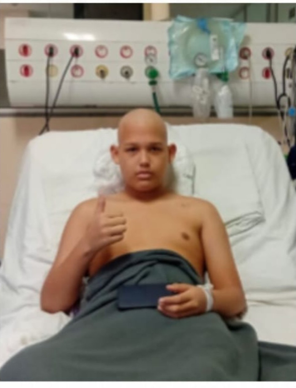 Ytalo Gabriel no leito do hospital, fazendo sinal de positivo